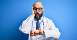 A doctor looks surprised after looking at his watch