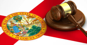 A judge's wooden gavel is sitting atop the Florida state flag