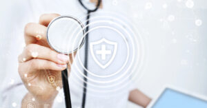 A doctor holding up a stethoscope with a shield and cross in the foreground representing security