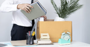 A businessman packing up his office items in a cardboard box