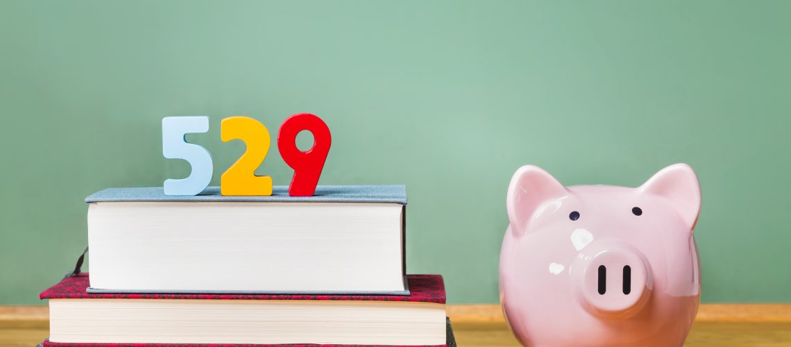 529 college savings plan theme with textbooks and piggy bank and green chalkboard background