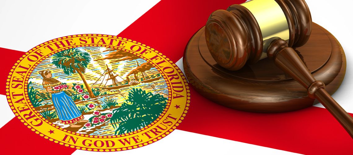 A judge's wooden gavel is sitting atop the Florida state flag