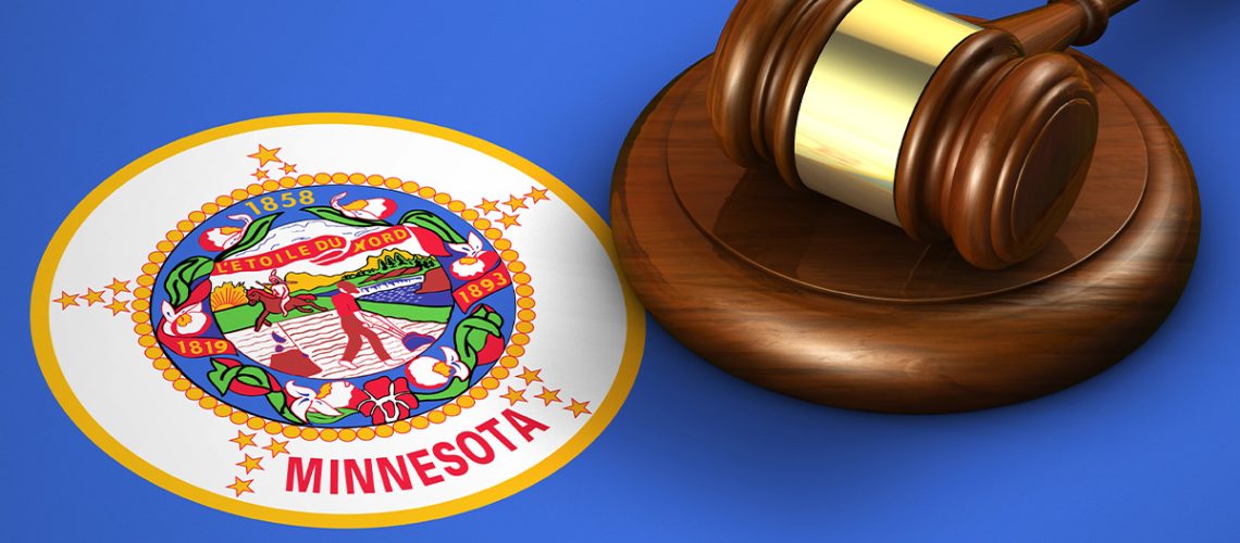 A wooden gavel sits atop the Minnesota state flag