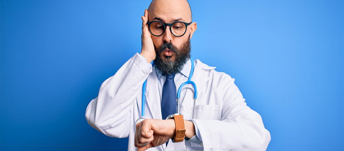 A doctor looks surprised after looking at his watch